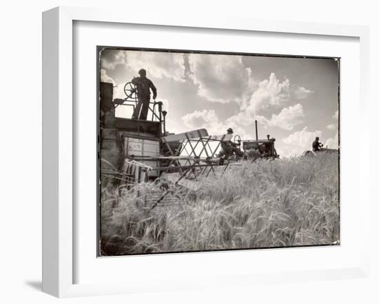 Kansas Farmer Driving Farmall Tractor as He Pulls a Manned Combine During Wheat Harvest-Margaret Bourke-White-Framed Photographic Print