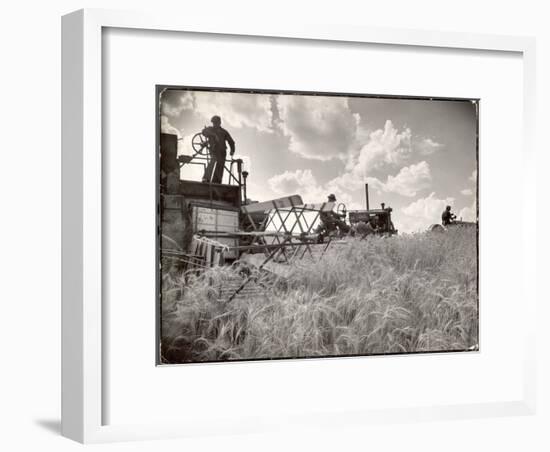 Kansas Farmer Driving Farmall Tractor as He Pulls a Manned Combine During Wheat Harvest-Margaret Bourke-White-Framed Photographic Print