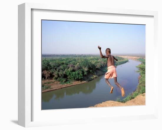 Karo Boy Leaps Off a Cliff Over the Omo River, Ethiopia-Janis Miglavs-Framed Photographic Print