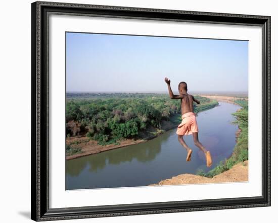 Karo Boy Leaps Off a Cliff Over the Omo River, Ethiopia-Janis Miglavs-Framed Photographic Print