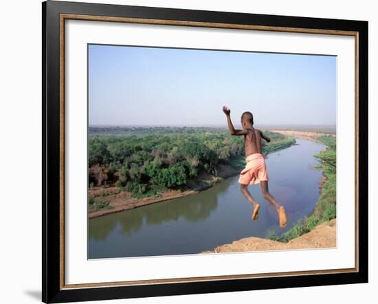 Karo Boy Leaps Off a Cliff Over the Omo River, Ethiopia-Janis Miglavs-Framed Photographic Print