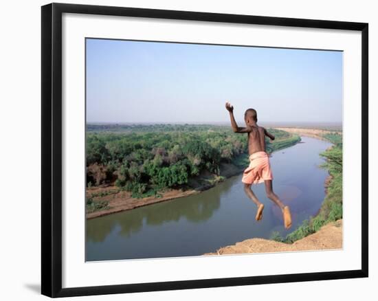 Karo Boy Leaps Off a Cliff Over the Omo River, Ethiopia-Janis Miglavs-Framed Photographic Print