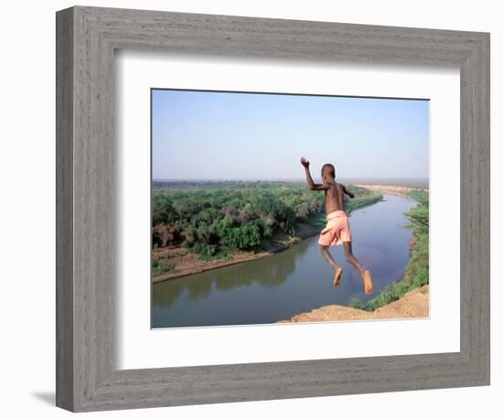 Karo Boy Leaps Off a Cliff Over the Omo River, Ethiopia-Janis Miglavs-Framed Photographic Print