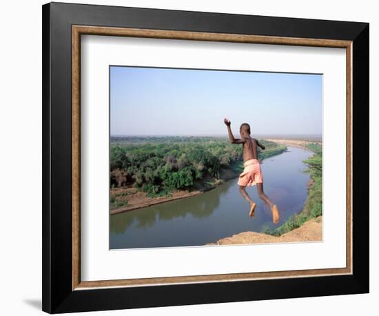 Karo Boy Leaps Off a Cliff Over the Omo River, Ethiopia-Janis Miglavs-Framed Photographic Print