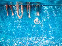 Children's and Adults Legs Underwater in the Swimming Pool-Kateryna Mostova-Photographic Print