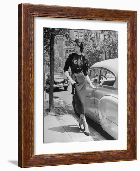 Katherine Cassidy Wearing a Red Fraostmann Wool Skirt and Black Sweater Beneath Black Cardigan-Nina Leen-Framed Photographic Print