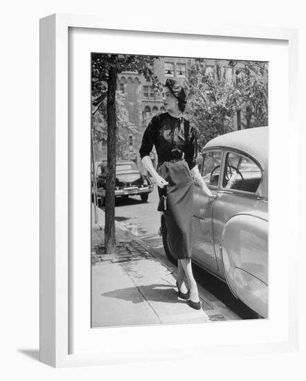 Katherine Cassidy Wearing a Red Fraostmann Wool Skirt and Black Sweater Beneath Black Cardigan-Nina Leen-Framed Photographic Print