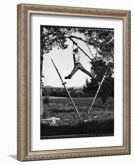 Kenneth Merriman Swinging on Tree Limb After Kicking Away Stilts-Robert W^ Kelley-Framed Photographic Print