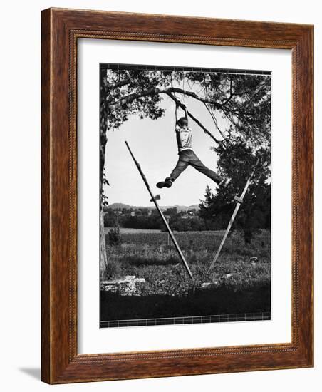 Kenneth Merriman Swinging on Tree Limb After Kicking Away Stilts-Robert W^ Kelley-Framed Photographic Print