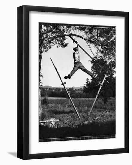 Kenneth Merriman Swinging on Tree Limb After Kicking Away Stilts-Robert W^ Kelley-Framed Photographic Print