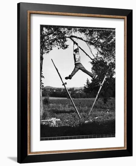 Kenneth Merriman Swinging on Tree Limb After Kicking Away Stilts-Robert W^ Kelley-Framed Photographic Print