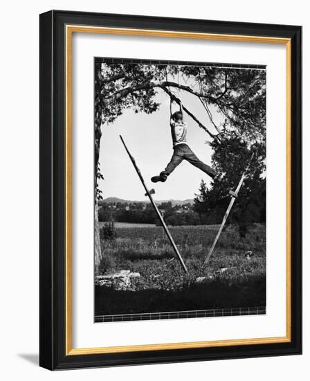 Kenneth Merriman Swinging on Tree Limb After Kicking Away Stilts-Robert W^ Kelley-Framed Photographic Print