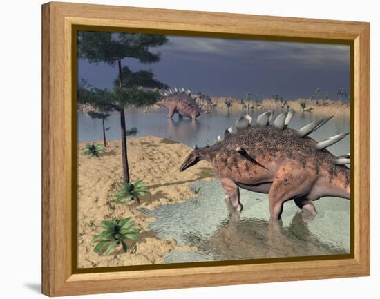 Kentrosaurus Dinosaurs Walking in the Water Next to Sand and Trees-null-Framed Stretched Canvas