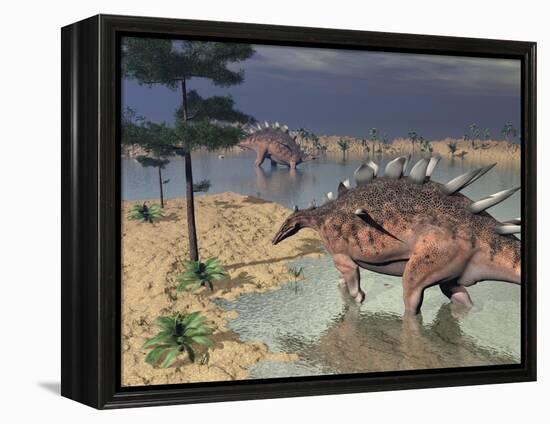 Kentrosaurus Dinosaurs Walking in the Water Next to Sand and Trees-null-Framed Stretched Canvas