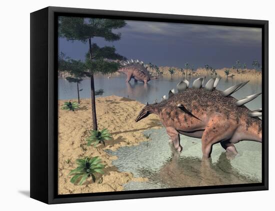 Kentrosaurus Dinosaurs Walking in the Water Next to Sand and Trees-null-Framed Stretched Canvas