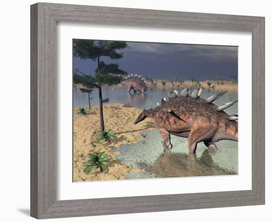 Kentrosaurus Dinosaurs Walking in the Water Next to Sand and Trees-null-Framed Art Print