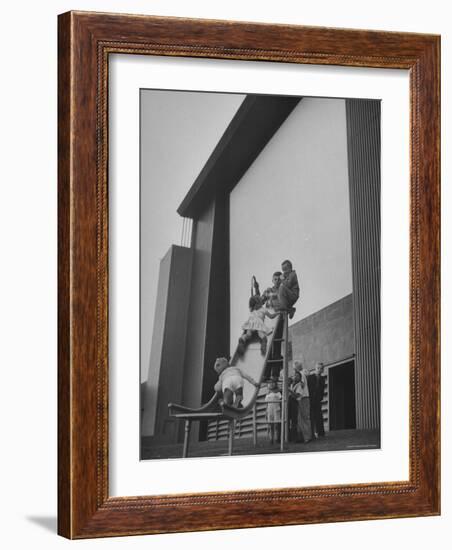 Kids Enjoying Slide in Mini Playground in Front of Rancho Drive-Allan Grant-Framed Photographic Print