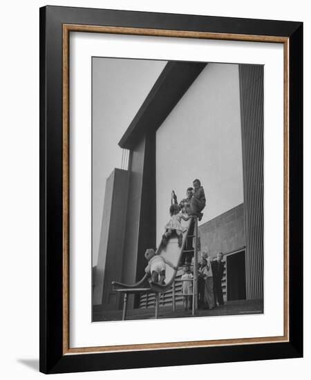 Kids Enjoying Slide in Mini Playground in Front of Rancho Drive-Allan Grant-Framed Photographic Print