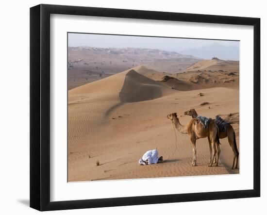 Kneeling to Pray in Desert, Holding Camels by Halters to Prevent Them Wandering Off Amongst Dunes-John Warburton-lee-Framed Photographic Print