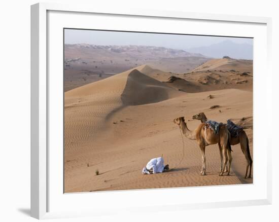 Kneeling to Pray in Desert, Holding Camels by Halters to Prevent Them Wandering Off Amongst Dunes-John Warburton-lee-Framed Photographic Print