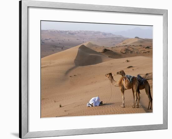 Kneeling to Pray in Desert, Holding Camels by Halters to Prevent Them Wandering Off Amongst Dunes-John Warburton-lee-Framed Photographic Print