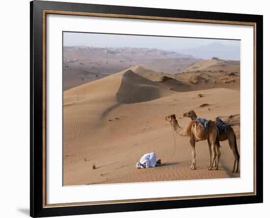 Kneeling to Pray in Desert, Holding Camels by Halters to Prevent Them Wandering Off Amongst Dunes-John Warburton-lee-Framed Photographic Print