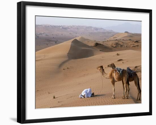 Kneeling to Pray in Desert, Holding Camels by Halters to Prevent Them Wandering Off Amongst Dunes-John Warburton-lee-Framed Photographic Print