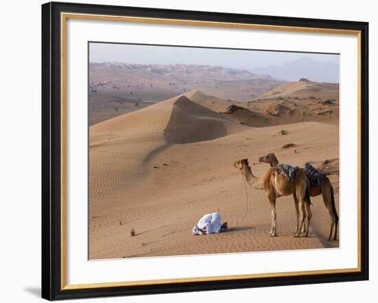 Kneeling to Pray in Desert, Holding Camels by Halters to Prevent Them Wandering Off Amongst Dunes-John Warburton-lee-Framed Photographic Print