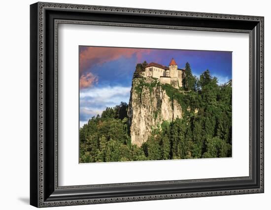 Lake Bled Castle rises on cliffs above Lake Bled, Slovenia at sunset-Miva Stock-Framed Photographic Print