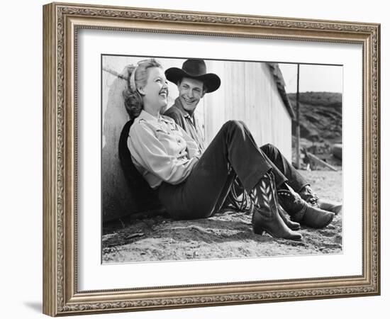 Laughing Couple in Western Attire Sitting on the Ground-null-Framed Photo