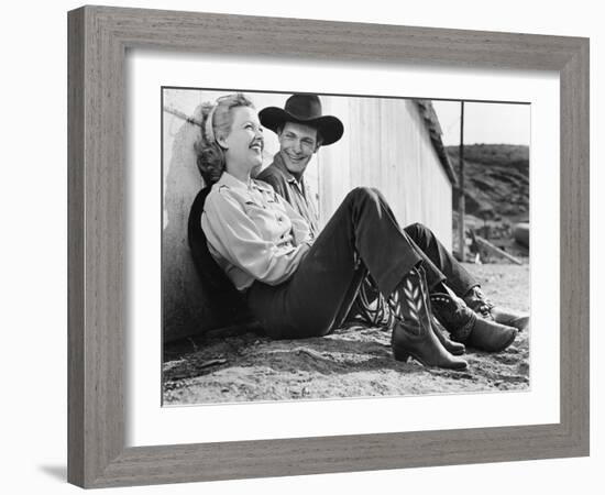 Laughing Couple in Western Attire Sitting on the Ground-null-Framed Photo