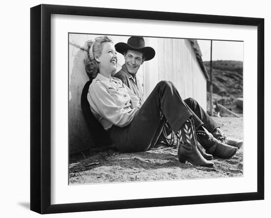 Laughing Couple in Western Attire Sitting on the Ground-null-Framed Photo