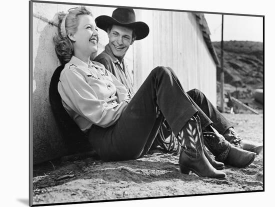 Laughing Couple in Western Attire Sitting on the Ground-null-Mounted Photo