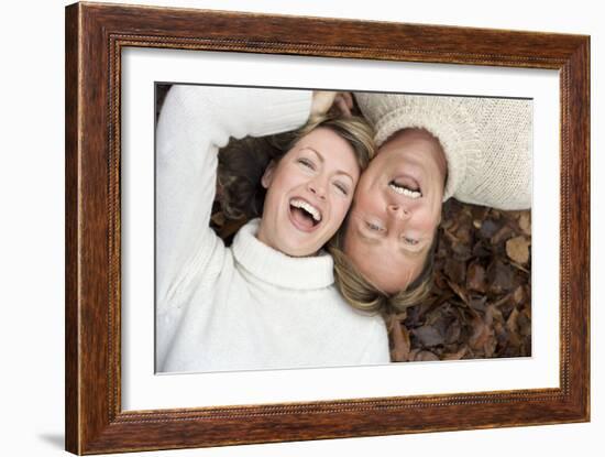 Laughing Couple Lying on Autumn Leaves-Ian Boddy-Framed Photographic Print