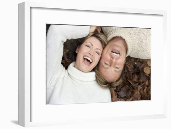 Laughing Couple Lying on Autumn Leaves-Ian Boddy-Framed Photographic Print