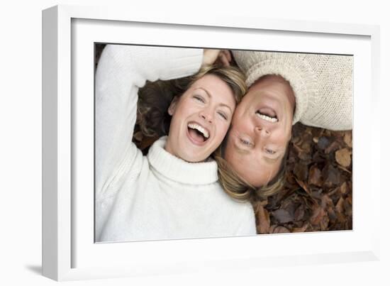 Laughing Couple Lying on Autumn Leaves-Ian Boddy-Framed Photographic Print