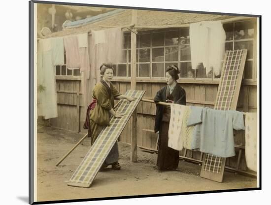 Laundry Day in Japan: Two Women Hang Up Clothes and Fabric to Dry Outdoors-null-Mounted Photographic Print