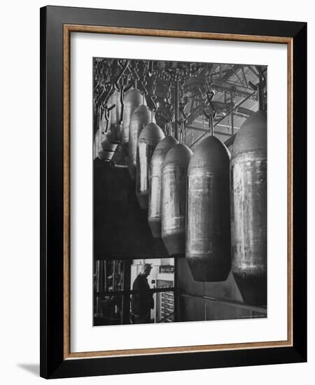 Line of 500 lbs Bombs Jiggling Along on Overhead Conveyor Hooks Abover Worker-Andreas Feininger-Framed Photographic Print