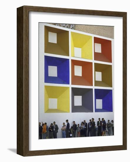 Line of People under Building Facade Painted with Brightly Colored Geometric Pattern-John Dominis-Framed Photographic Print