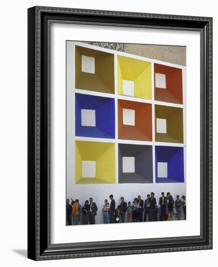 Line of People under Building Facade Painted with Brightly Colored Geometric Pattern-John Dominis-Framed Photographic Print