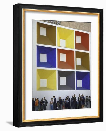 Line of People under Building Facade Painted with Brightly Colored Geometric Pattern-John Dominis-Framed Photographic Print