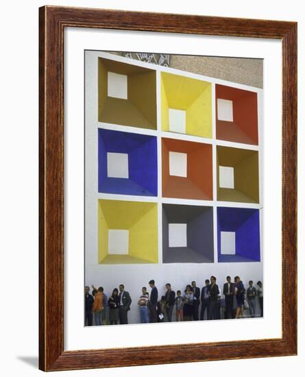 Line of People under Building Facade Painted with Brightly Colored Geometric Pattern-John Dominis-Framed Photographic Print