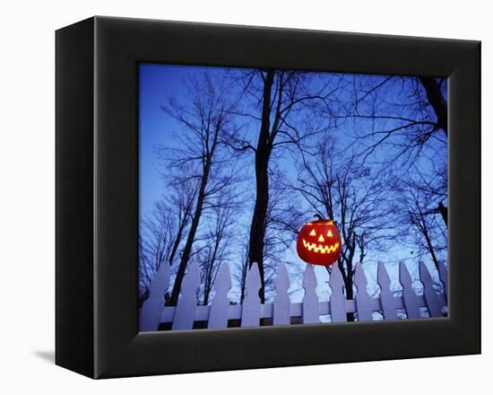 Lit Jack o'-Lantern Perched on Picket Fence-Ralph Morsch-Framed Premier Image Canvas