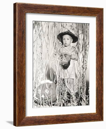 Little Boy in Halloween Costume Holding Mask Standing by Streamers-null-Framed Photo