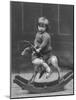 Little Boy on a Very Small Rocking Horse with a Whip in His Hand-null-Mounted Photographic Print