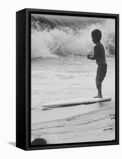 Little Boy Standing on a Surf Board Staring at the Water-Allan Grant-Framed Premier Image Canvas