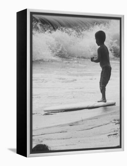 Little Boy Standing on a Surf Board Staring at the Water-Allan Grant-Framed Premier Image Canvas