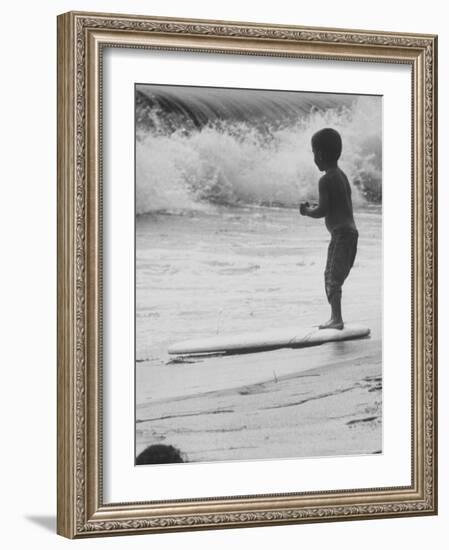 Little Boy Standing on a Surf Board Staring at the Water-Allan Grant-Framed Photographic Print