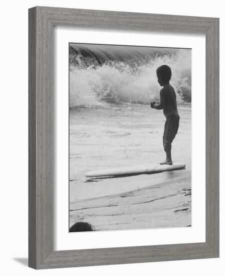 Little Boy Standing on a Surf Board Staring at the Water-Allan Grant-Framed Photographic Print