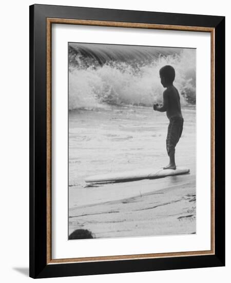 Little Boy Standing on a Surf Board Staring at the Water-Allan Grant-Framed Photographic Print